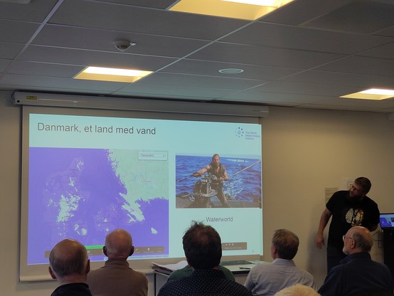 Slide showing Denmark if all ice melted in the world melted. There's not much land left. Next to a picture of Kevin Costner in the film Waterworld