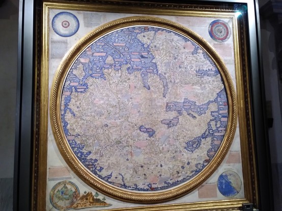 A medieval circular map of the world with lots of annorations in tiny script